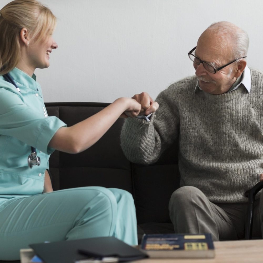 old-man-nursing-home-fist-bumping-nurse